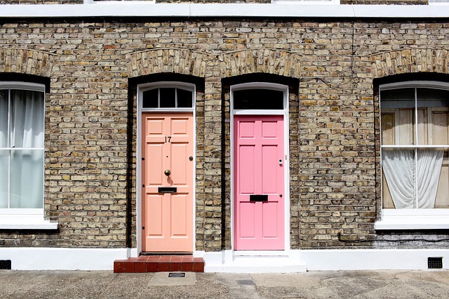 Ružové a oranžové dvere na tehlovom dome.jpg
